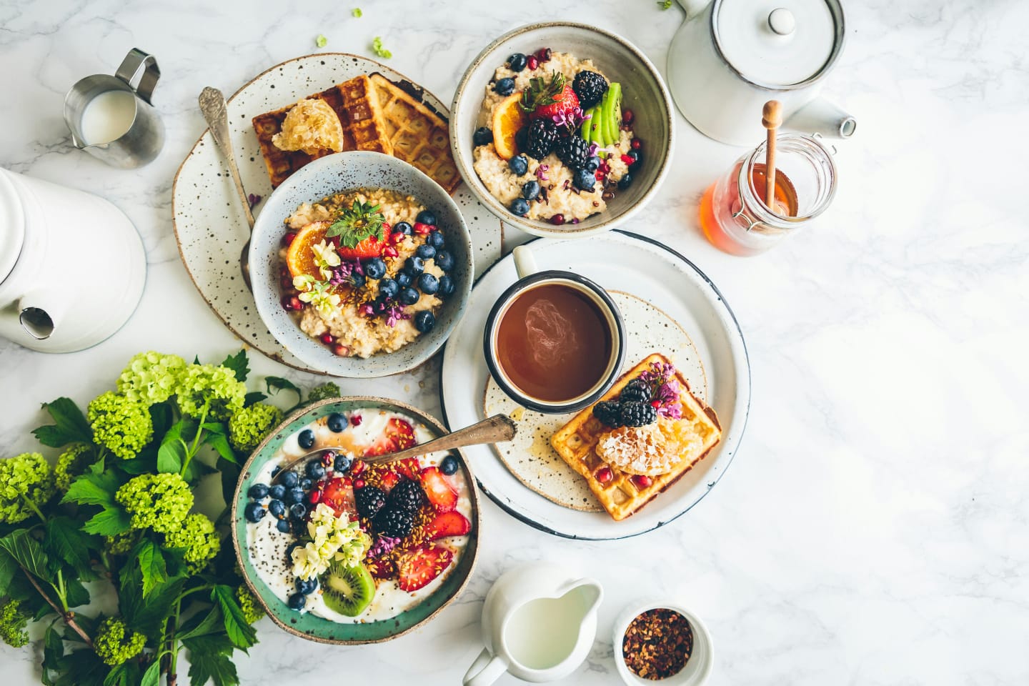 Colourful breakfast bowls, waffles and fruit on a table